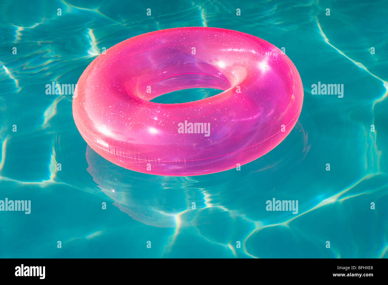 Pink Float Tube Floating in Swimming Pool Stock Photo - Alamy