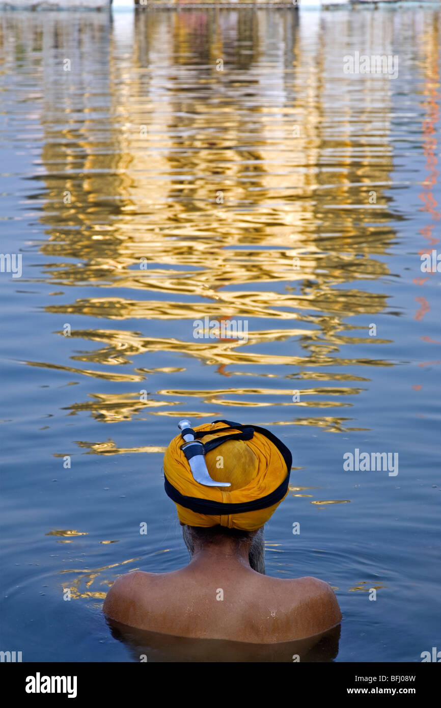 Sikh man bathing in the sacred pool (Amrit Sarovar). The Golden Temple. Amritsar. Punjab. India Stock Photo