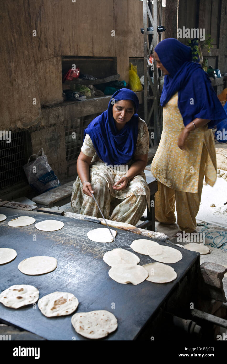 Indian women making chapatis (traditional bread). The Golden Temple