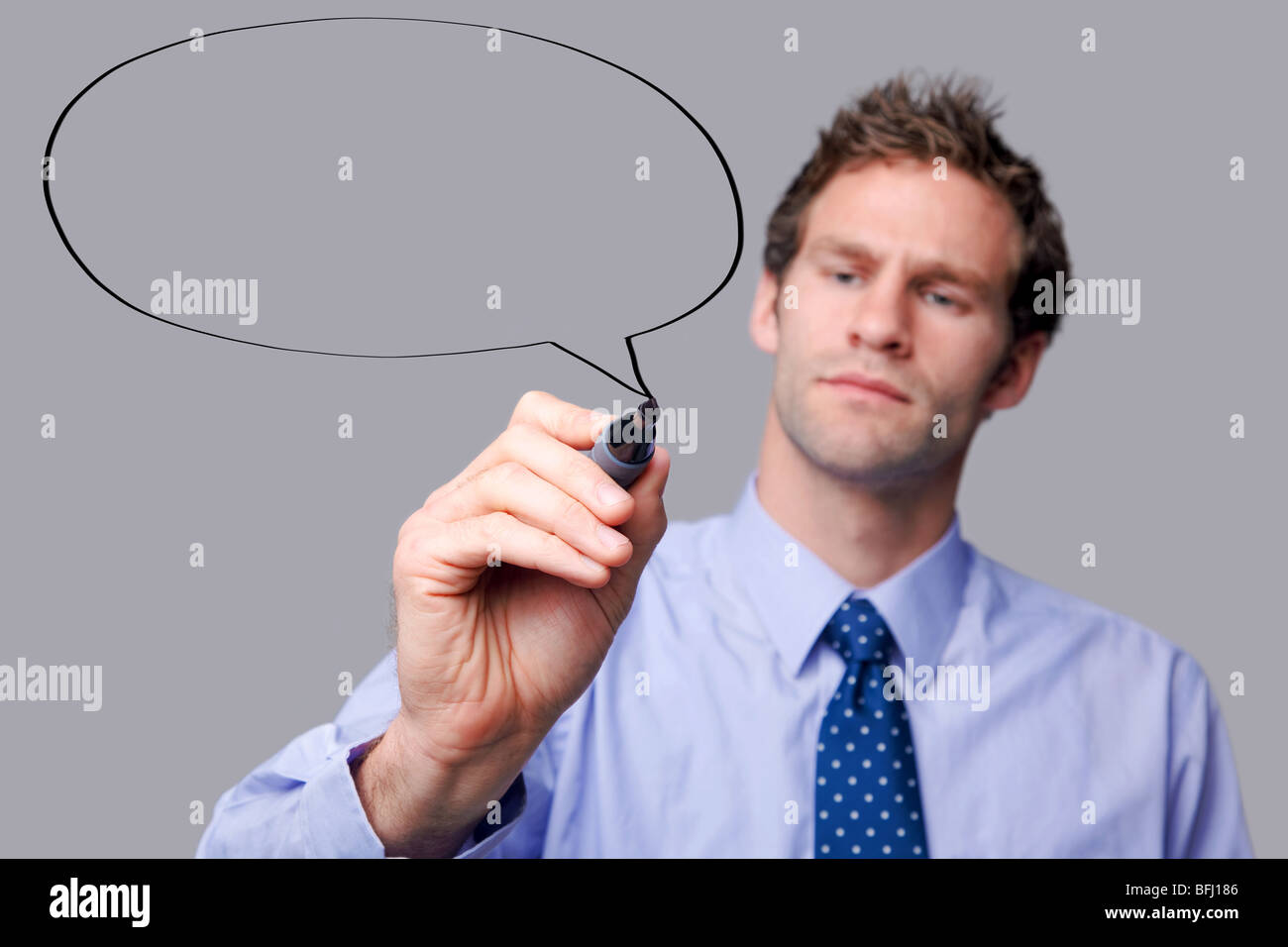 Businessman drawing a speech bubble on a glass screen Stock Photo