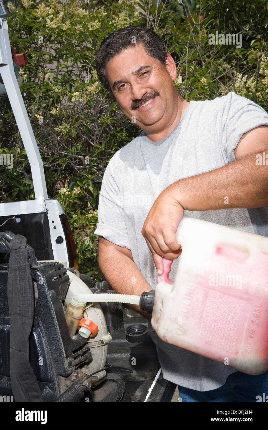 Portrait of man pouring fuel into lawn mower Stock Photo Alamy