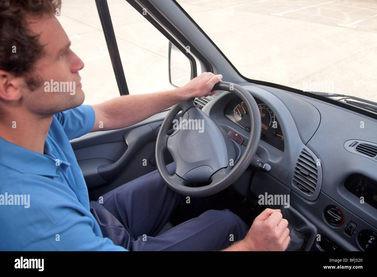 Van driver in a left hand drive vehicle. Also available as RHD, instrument panel is correct for both images. Stock Photo