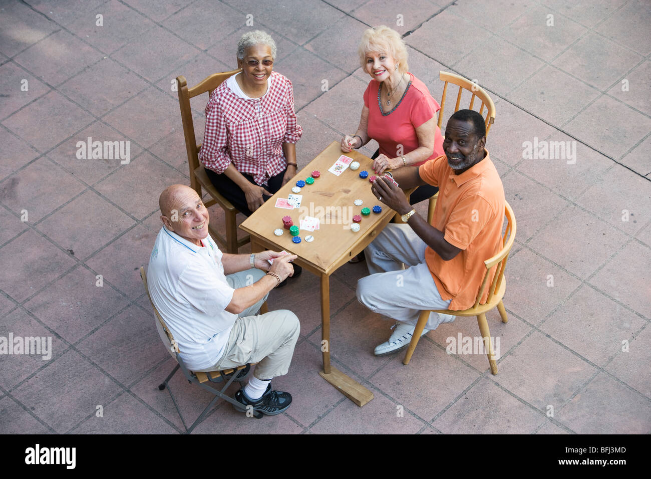 Senior people playing cards, smiling Stock Photo