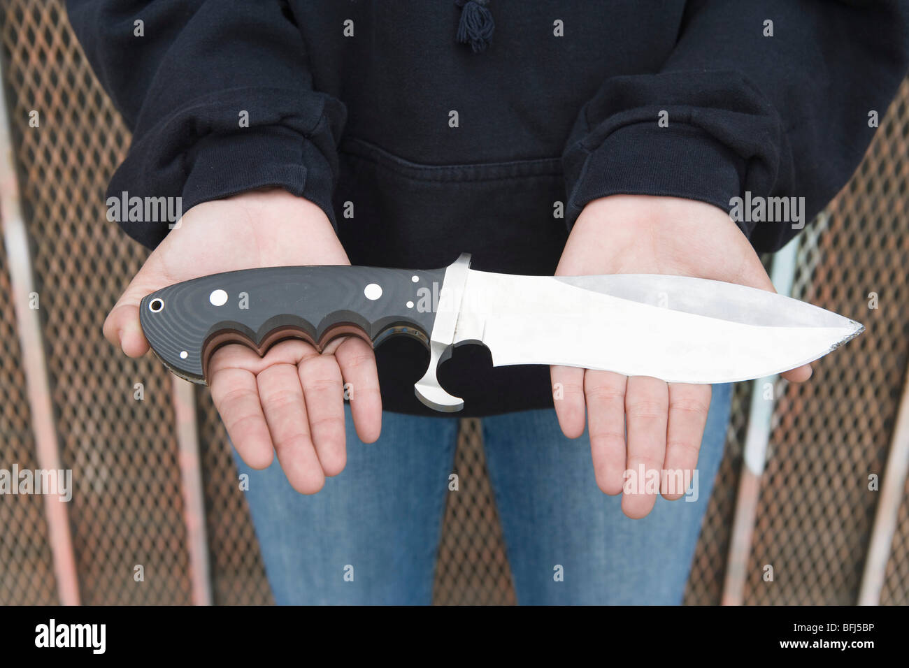 Young man holding knife on her palms Stock Photo