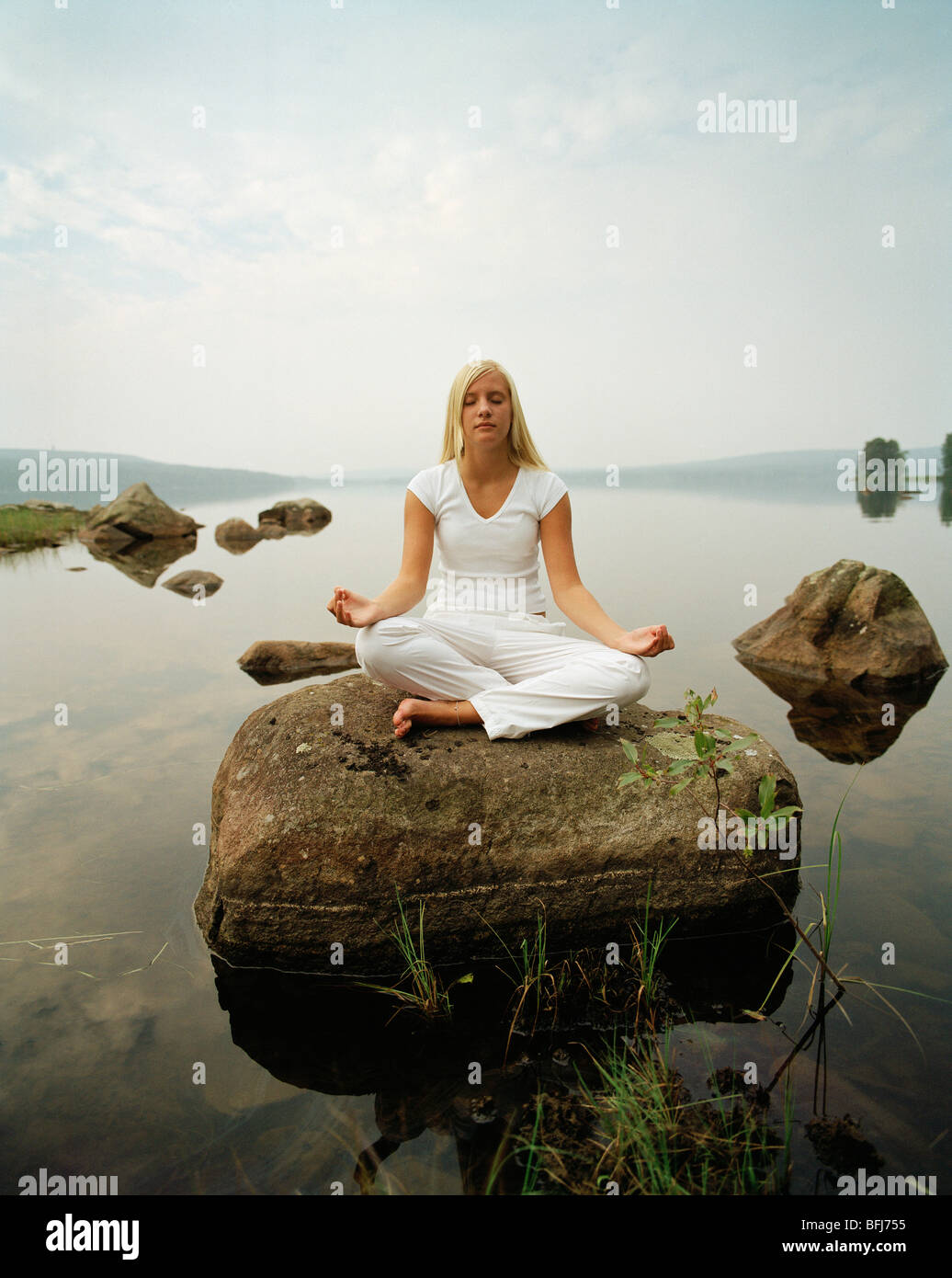 Young woman practising yoga by a lake, Sweden Stock Photo Alamy