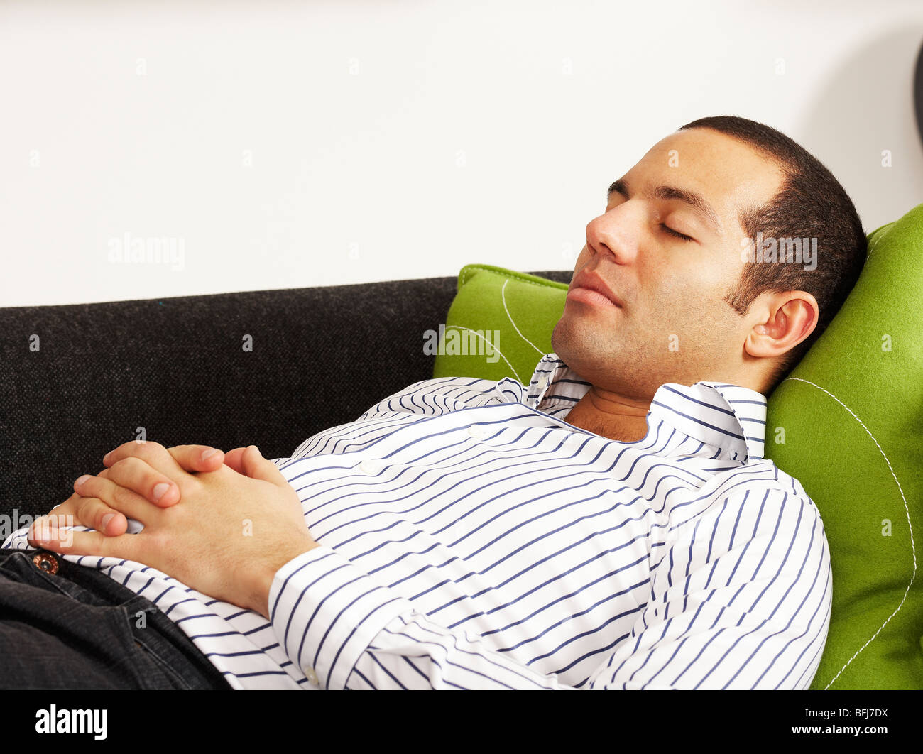 Businessman resting on a sofa, Sweden. Stock Photo