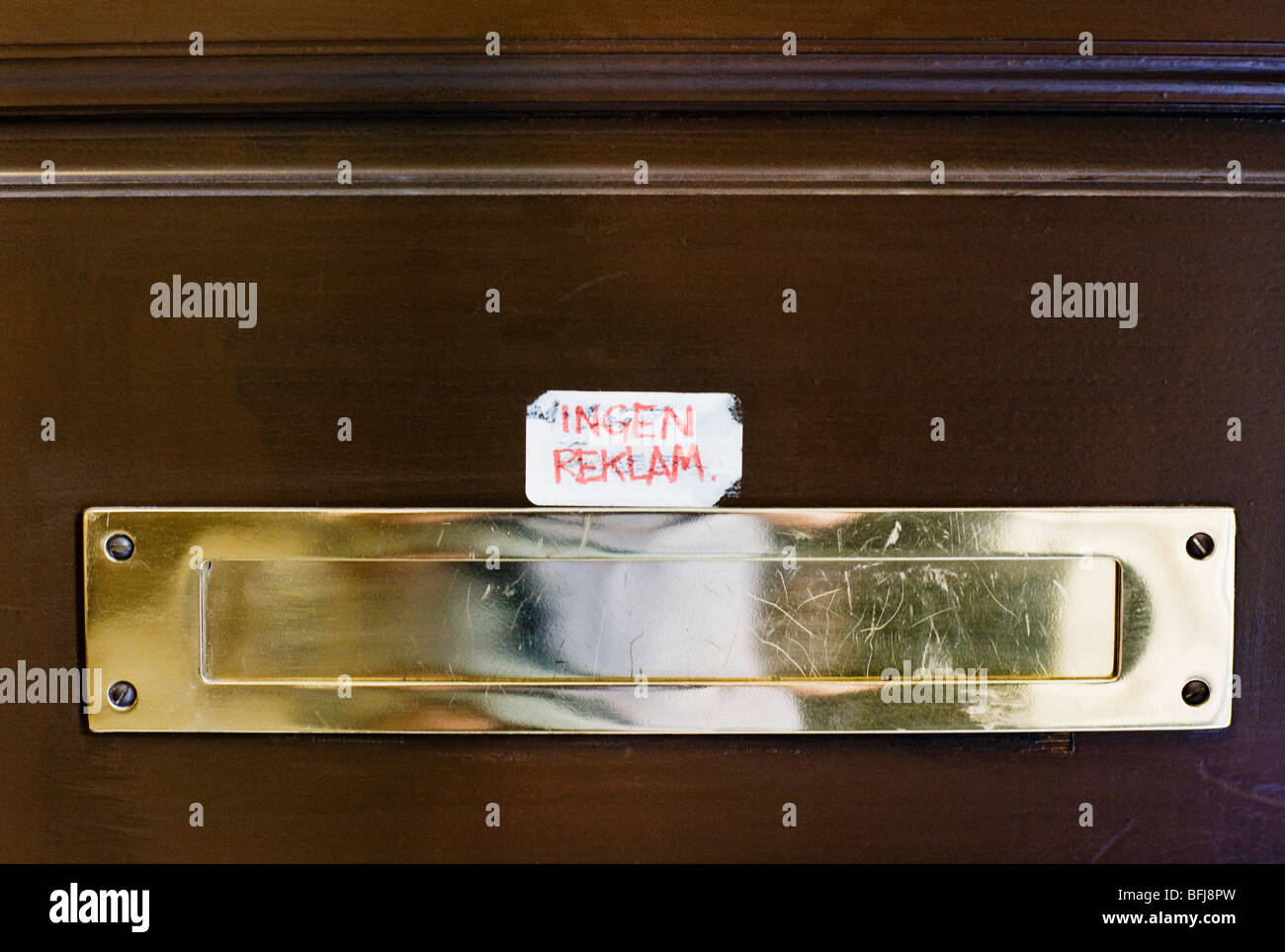 A handwritten message against advertising brochures by a letterbox, Sweden. Stock Photo