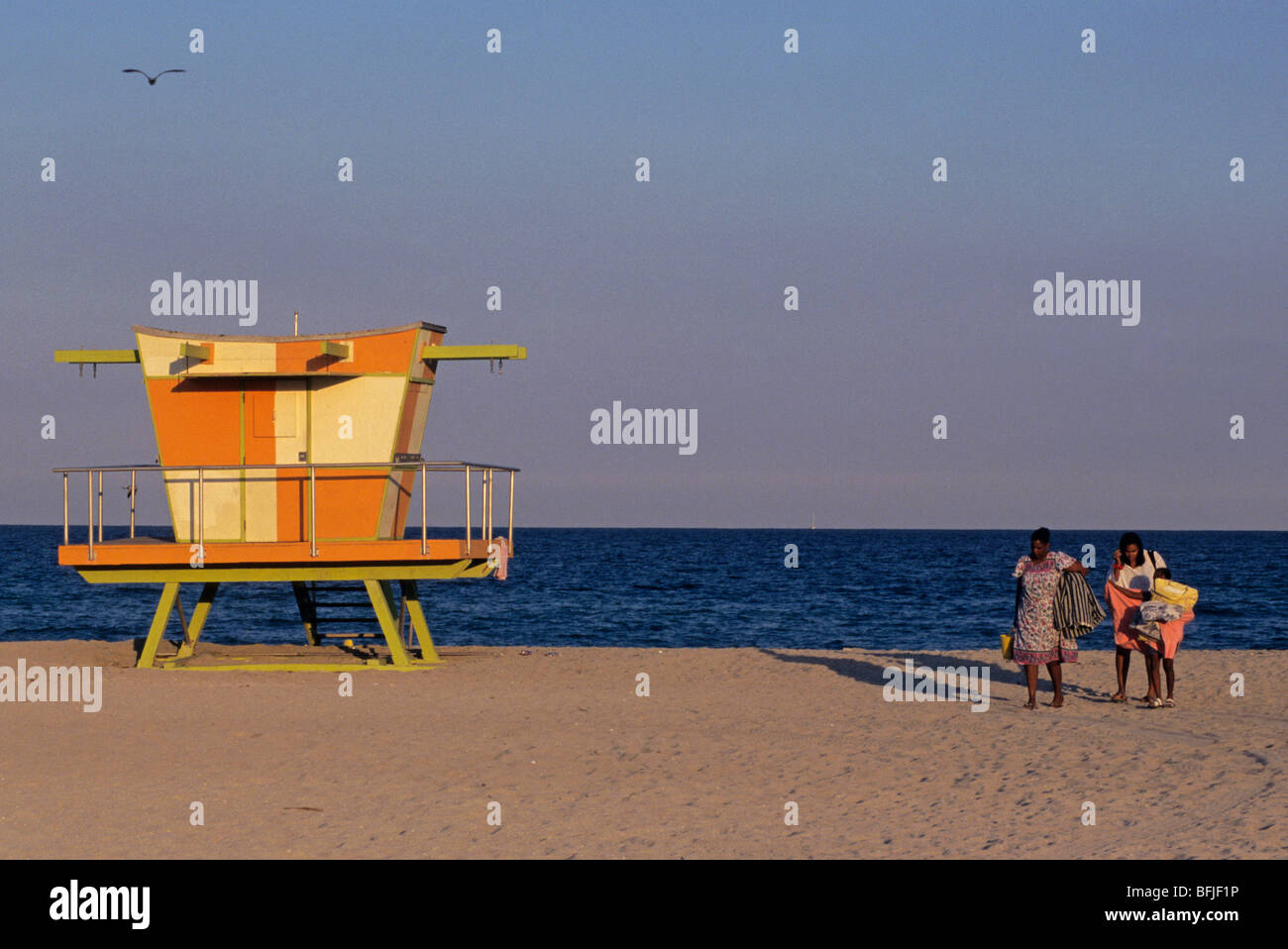 Lifeguard hut and Afro family leaving the beach at dusk Miami Beach