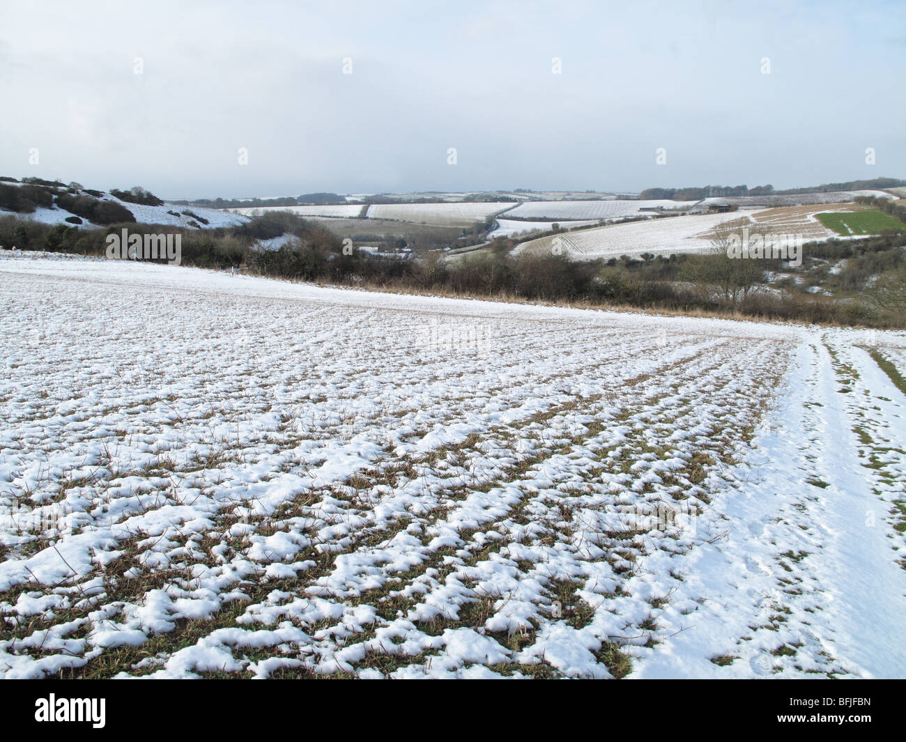 Snow covering ploughed fallow field on a cold winter day, Dorset Stock Photo