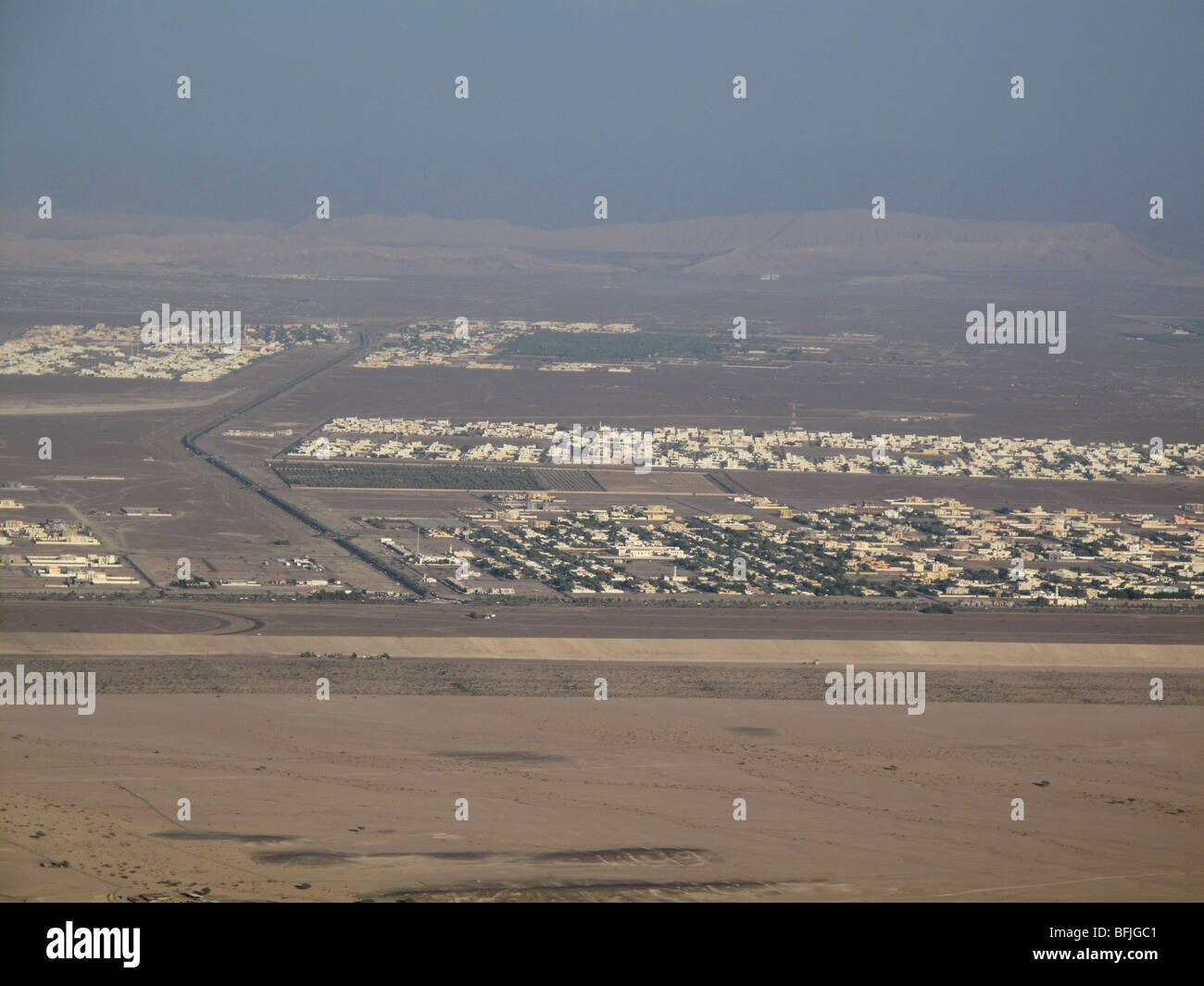 View from Jebel Hafeet mountain of single storey buildings and town in oasis town of Al Ain, UAE Stock Photo