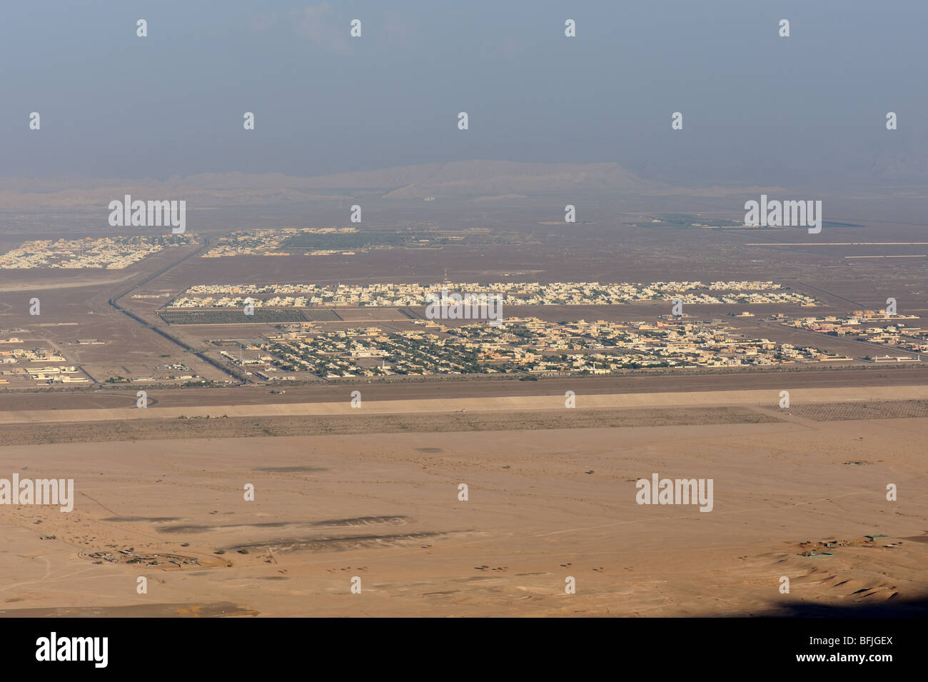 View from Jebel Hafeet mountain of single story buildings and town in oasis town of Al Ain, UAE Stock Photo