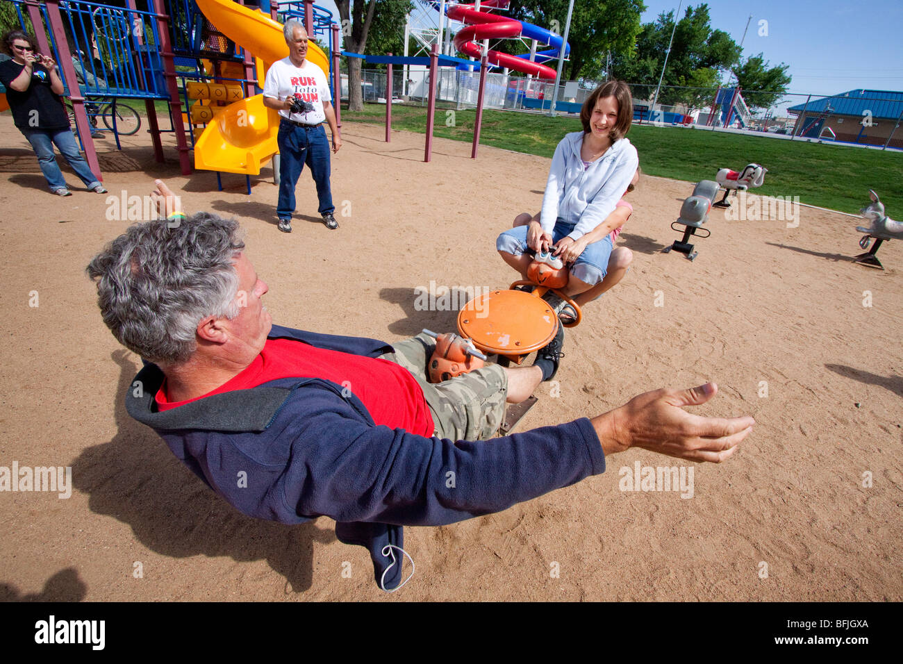 Adults play on a teetertotter in western Kansas, USA, June 10, 2009