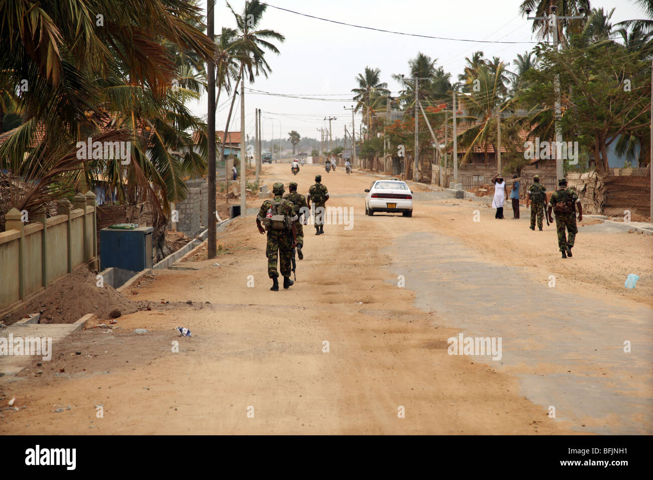 Government Sinhalese soldiers patrol the main street in Arugam Bay. Sri Lanka. Stock Photo