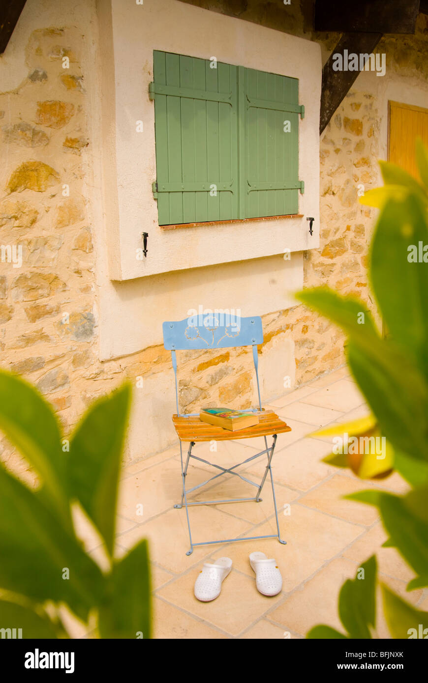 Chair with book and shoes on a villa terrace in Southern France Stock Photo
