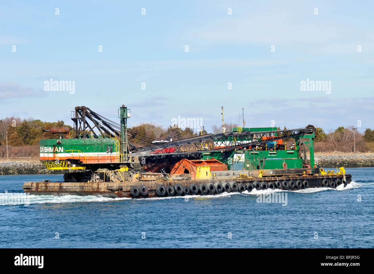 Crane being transported on a barge trough the Cape Cod Canal Stock Photo