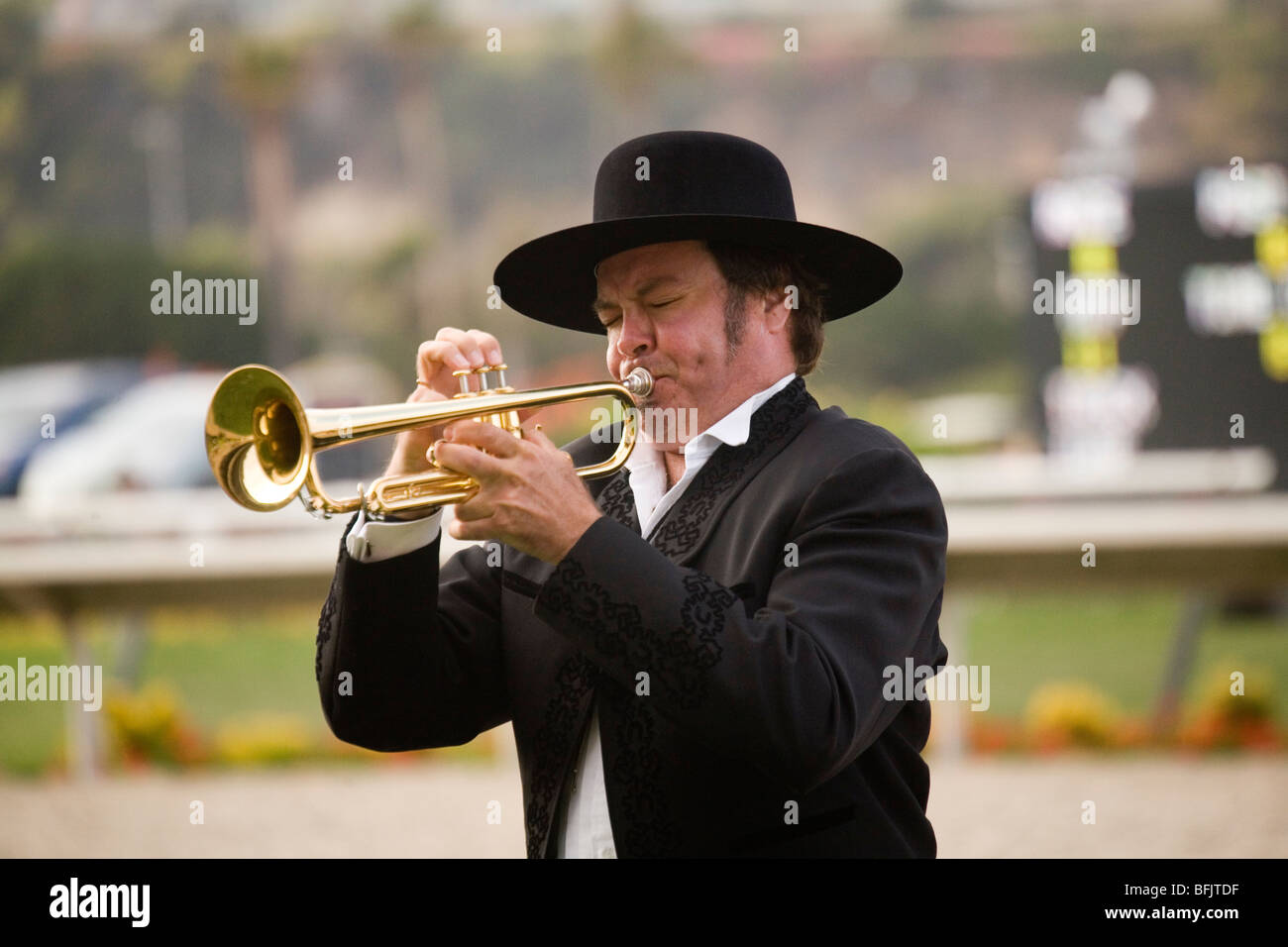 A man plays the call to post on his bugle, at a horse track at the Del Mar Fairgrounds in southern California. Stock Photo