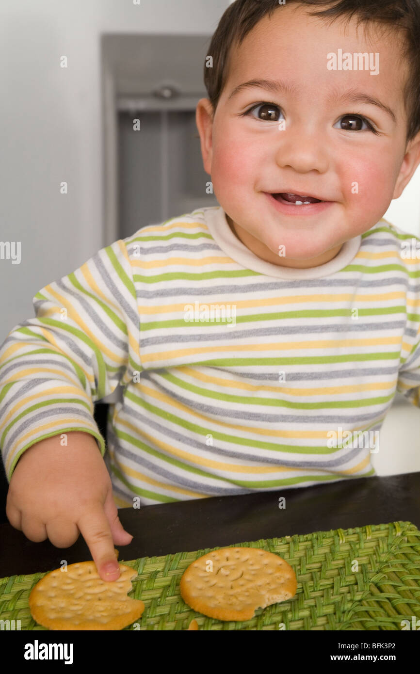 Hispanic baby boy eating crackers Stock Photo Alamy