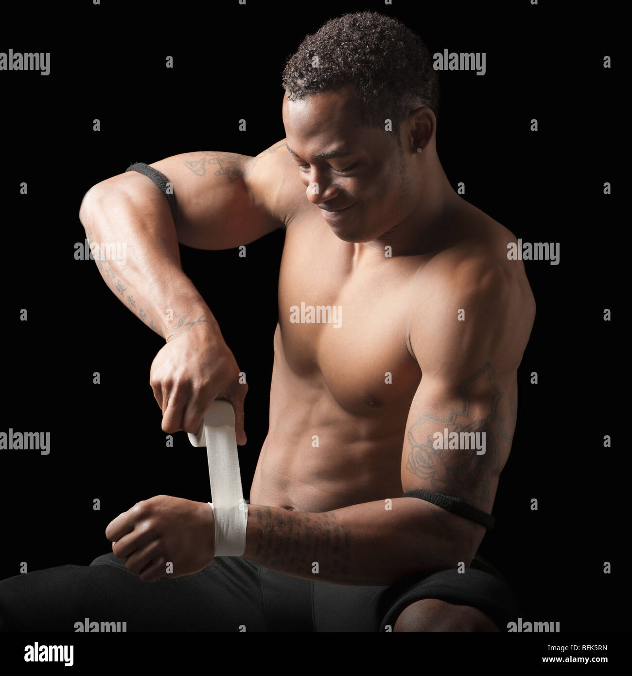 Bare chested football player taping wrist Stock Photo Alamy