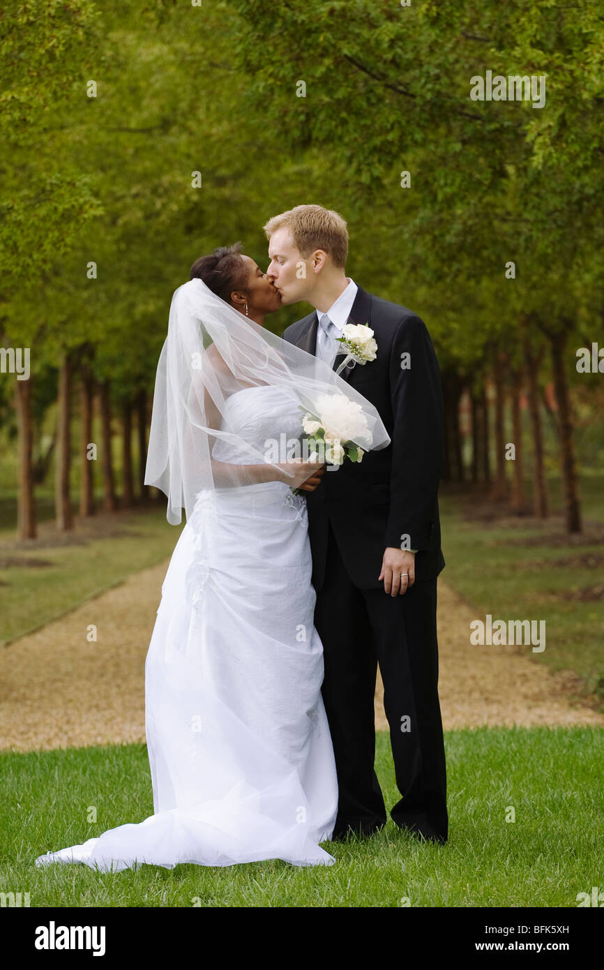 Bride and groom kissing in grass Stock Photo - Alamy