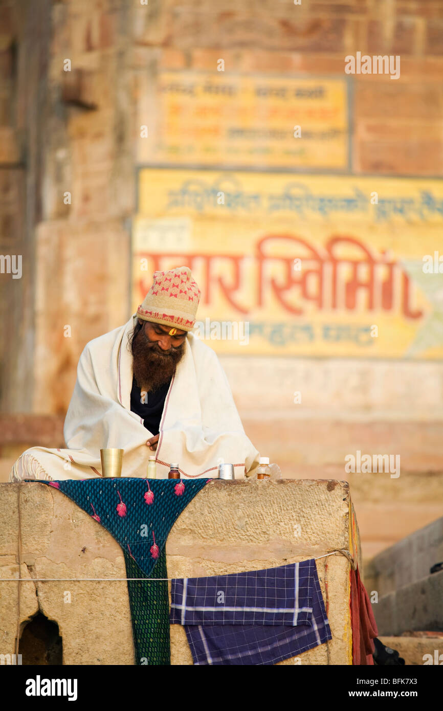 A man sits in comtemplation over the Ganges River in the Hindu holy city of Varanasi, India Stock Photo