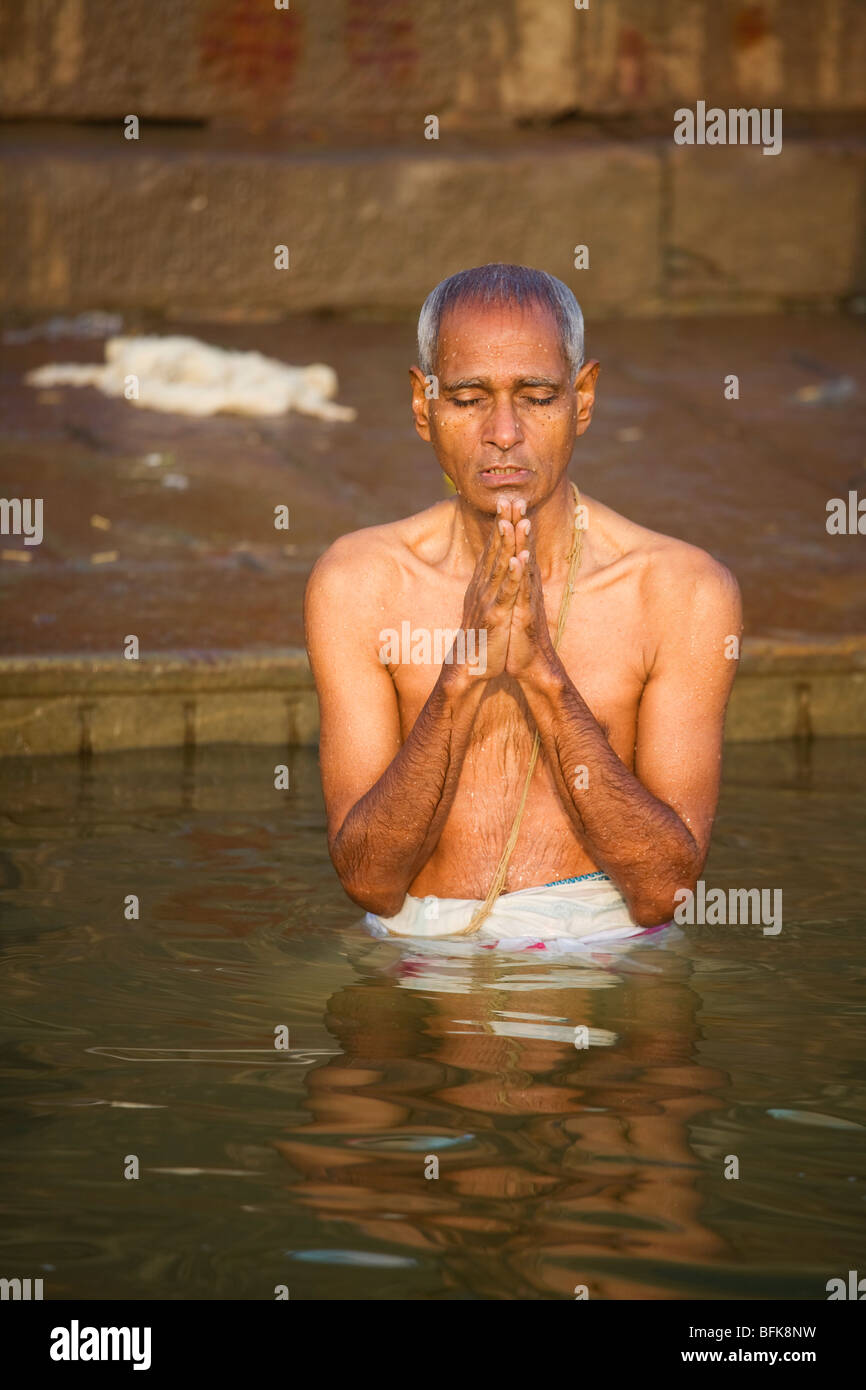 A man prays in the Ganges River at the Hindu holy city of Varanasi, India Stock Photo