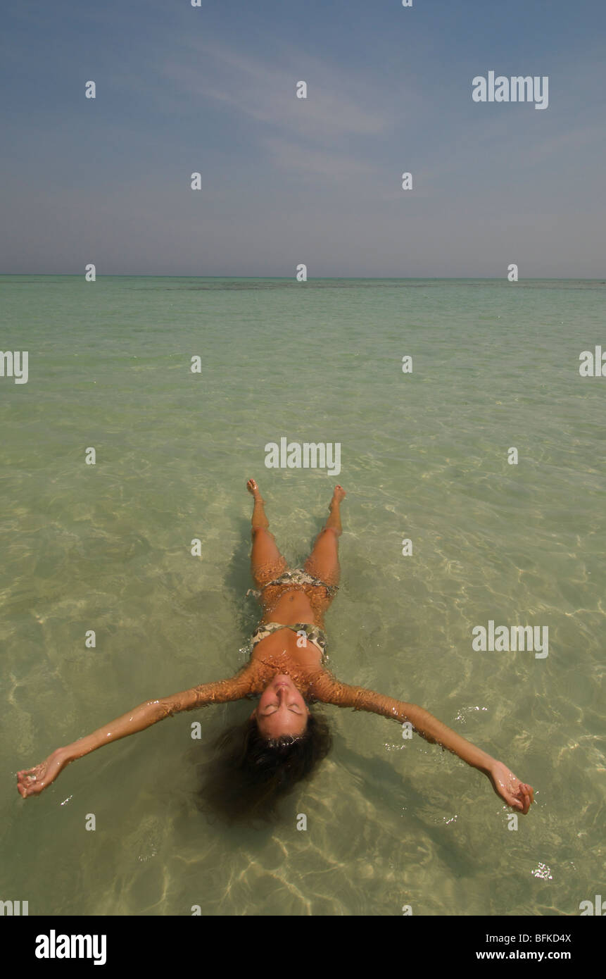 Girl floating on a beach in the Andaman islands, India Stock Photo