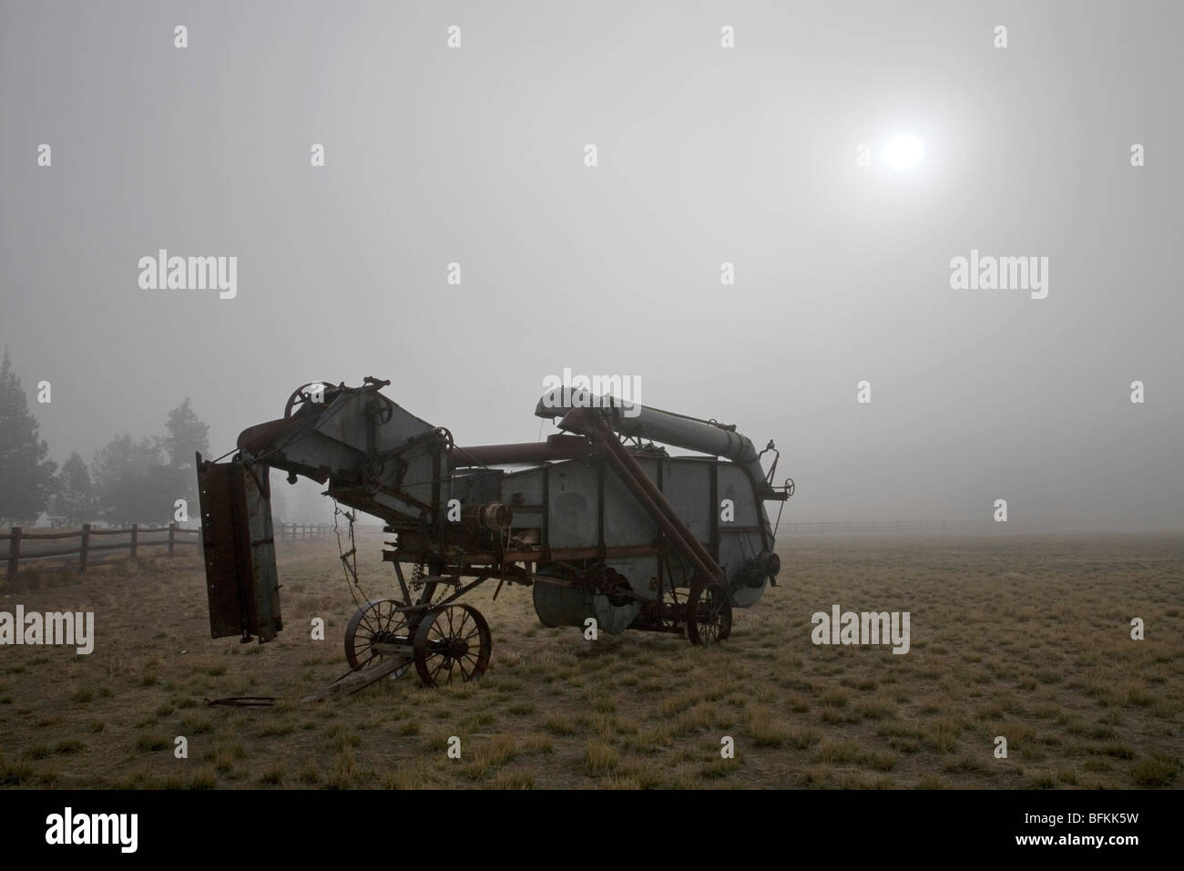 antique wheat combine on a foggy morning in Central Oregon Stock Photo