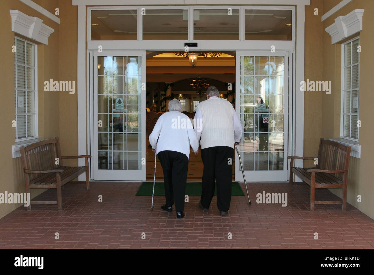 Two senior citizens entering a building Stock Photo