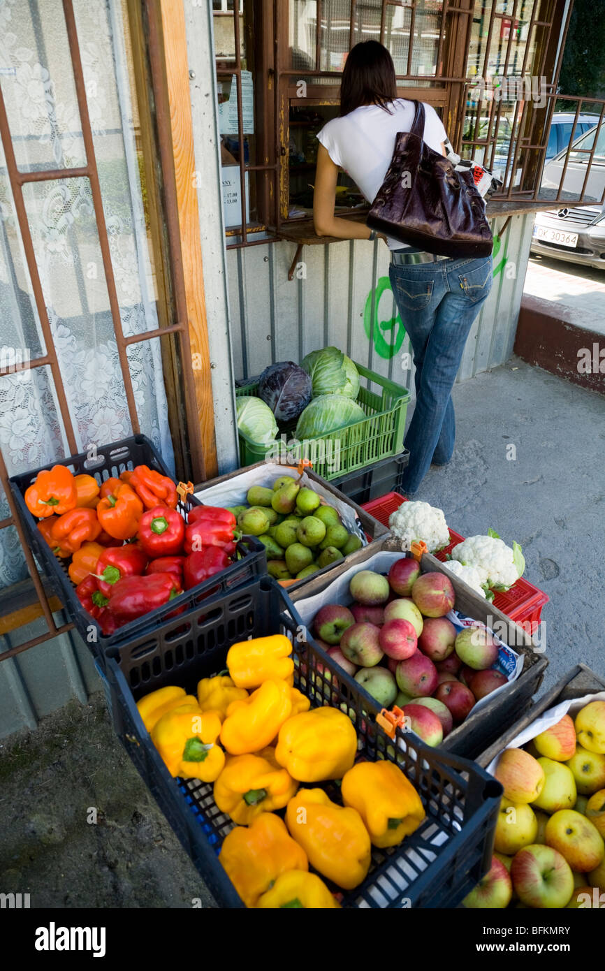 Customer pays at fresh fruit & vegetable local market stall on Polish residential housing estate. Kedzierzyn-Kozle town. Poland. Stock Photo