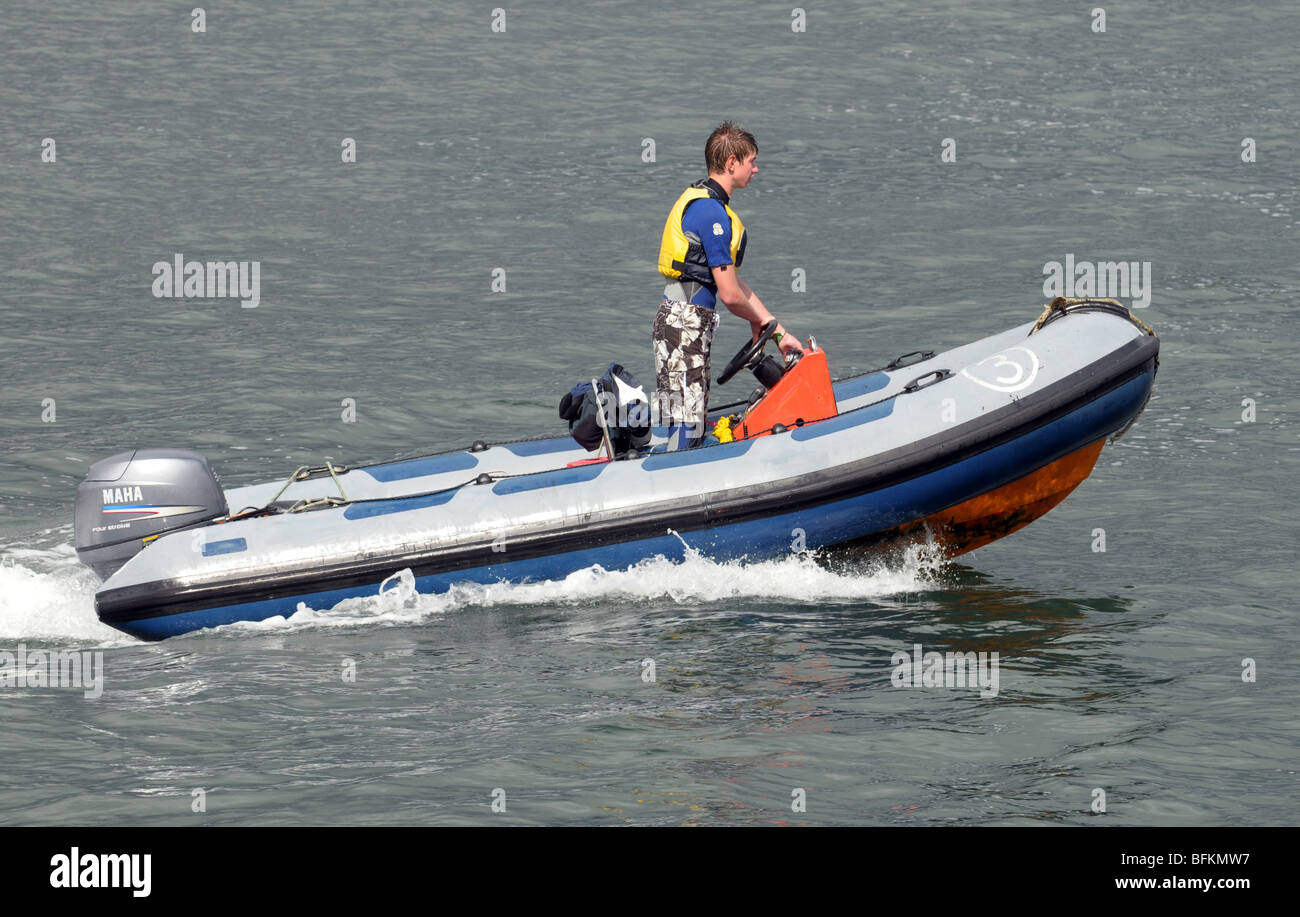 Boy steering a powerboat on the sea. Stock Photo