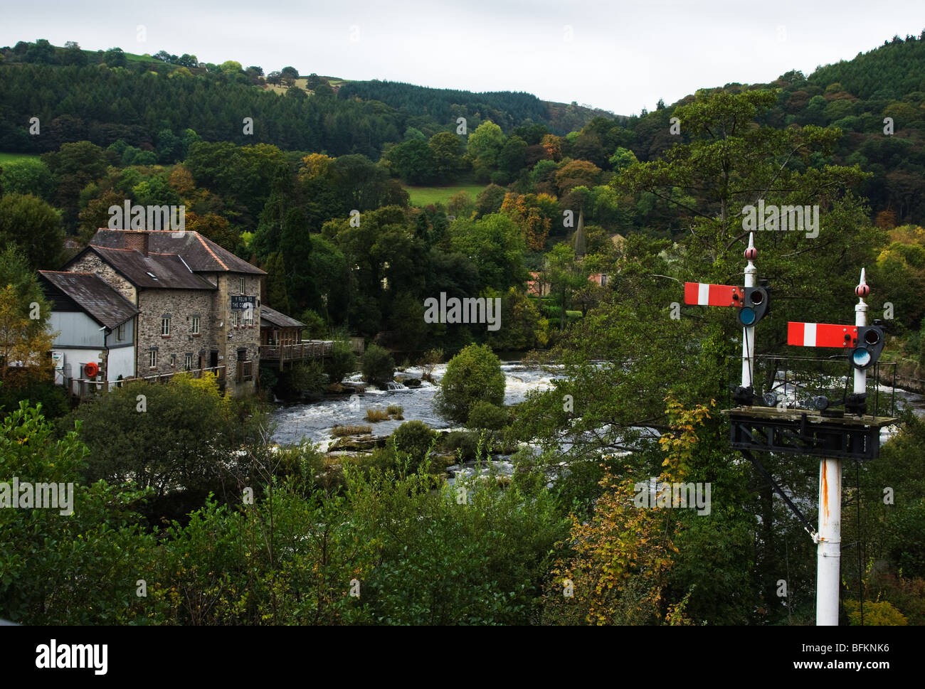 The old Corn Mill building in Llangollen by the river and including railway signals from the nearby steam railway Stock Photo