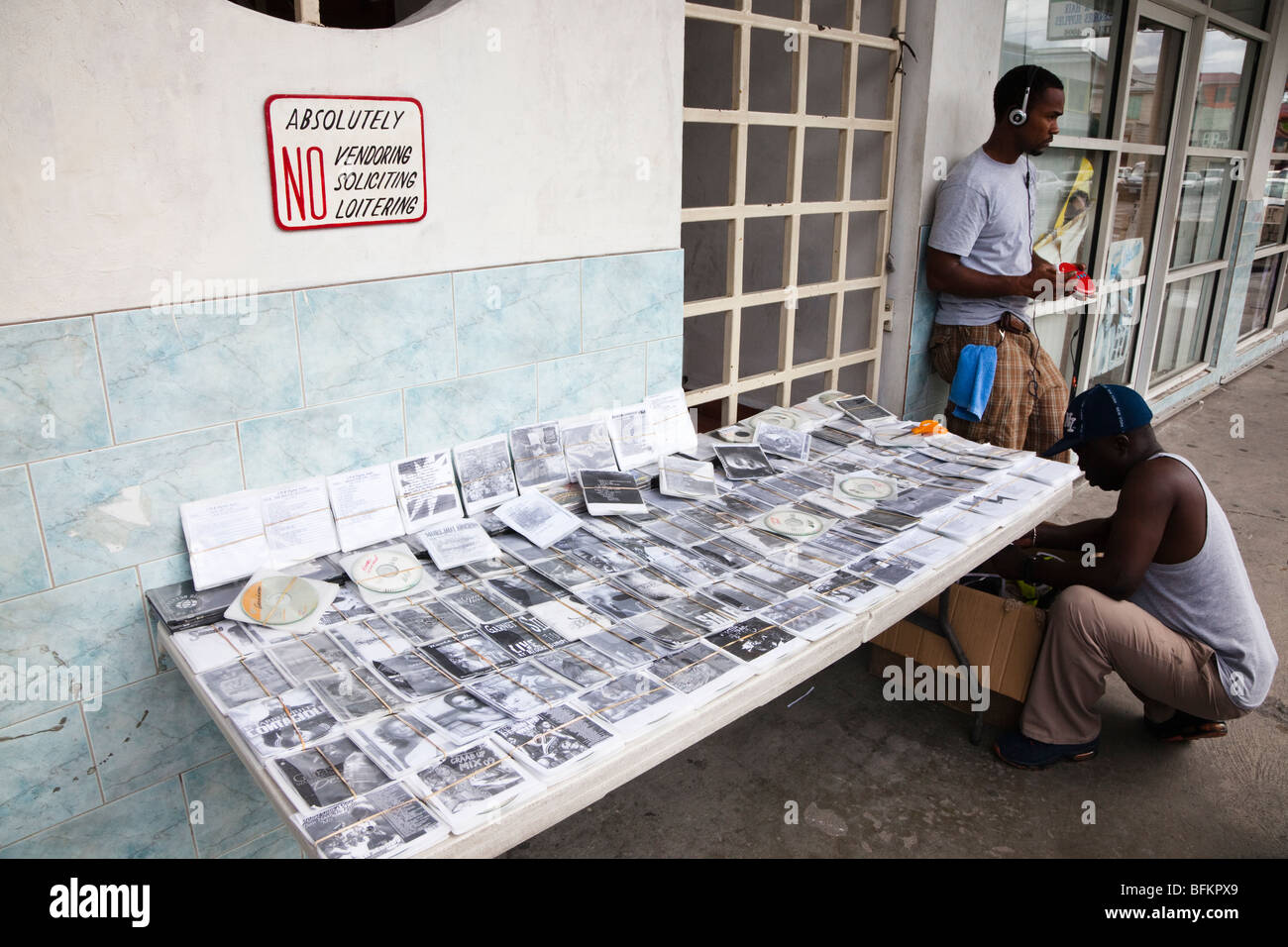 Illegal vendor selling bootleg CDs and Videos from a stall in St Johns town, Antigua, West Indies Stock Photo