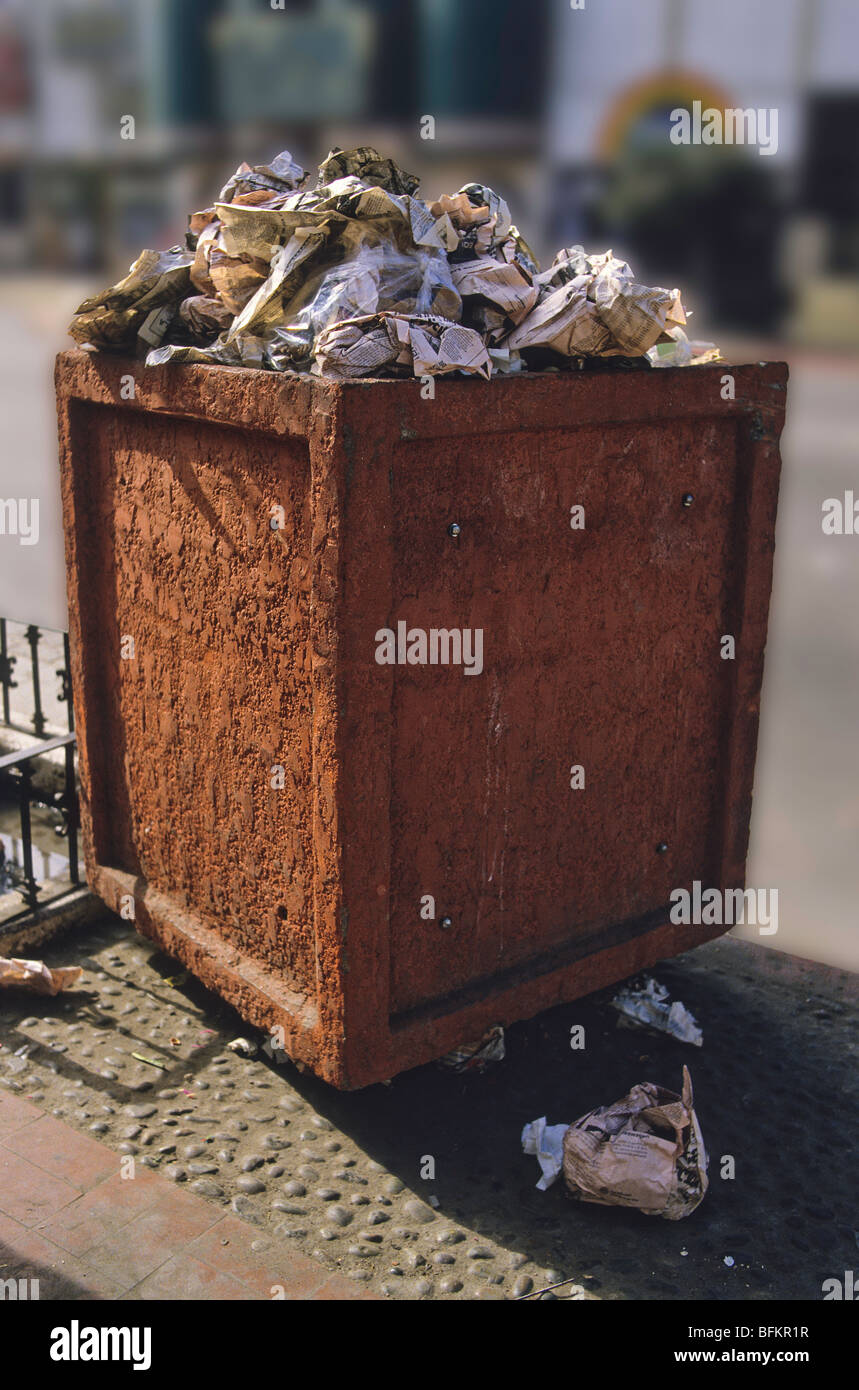 An overflowing municipal trash can sits on a curb Stock Photo Alamy