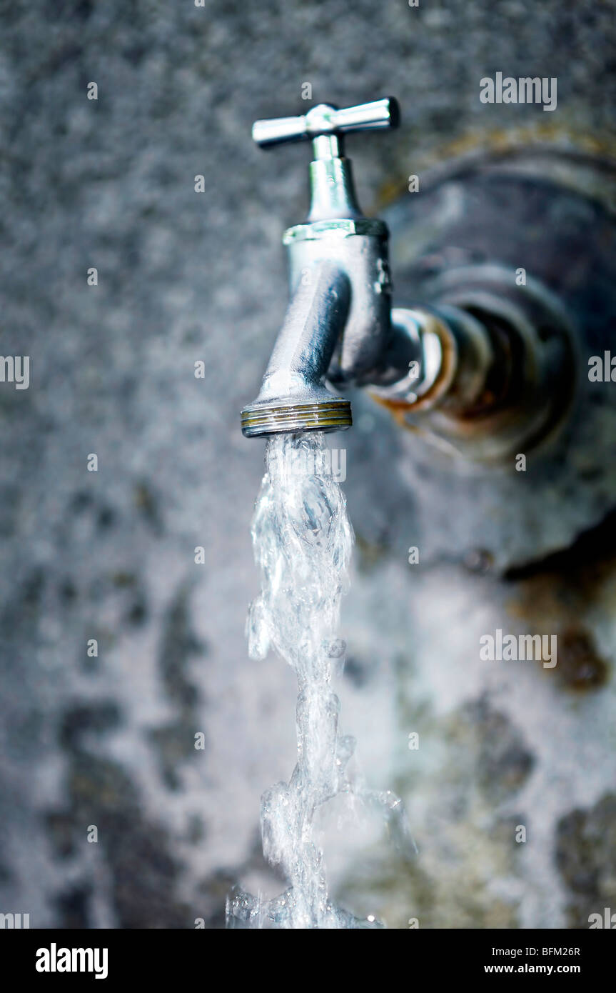 Closeup of water running from outdoor wall faucet Stock Photo