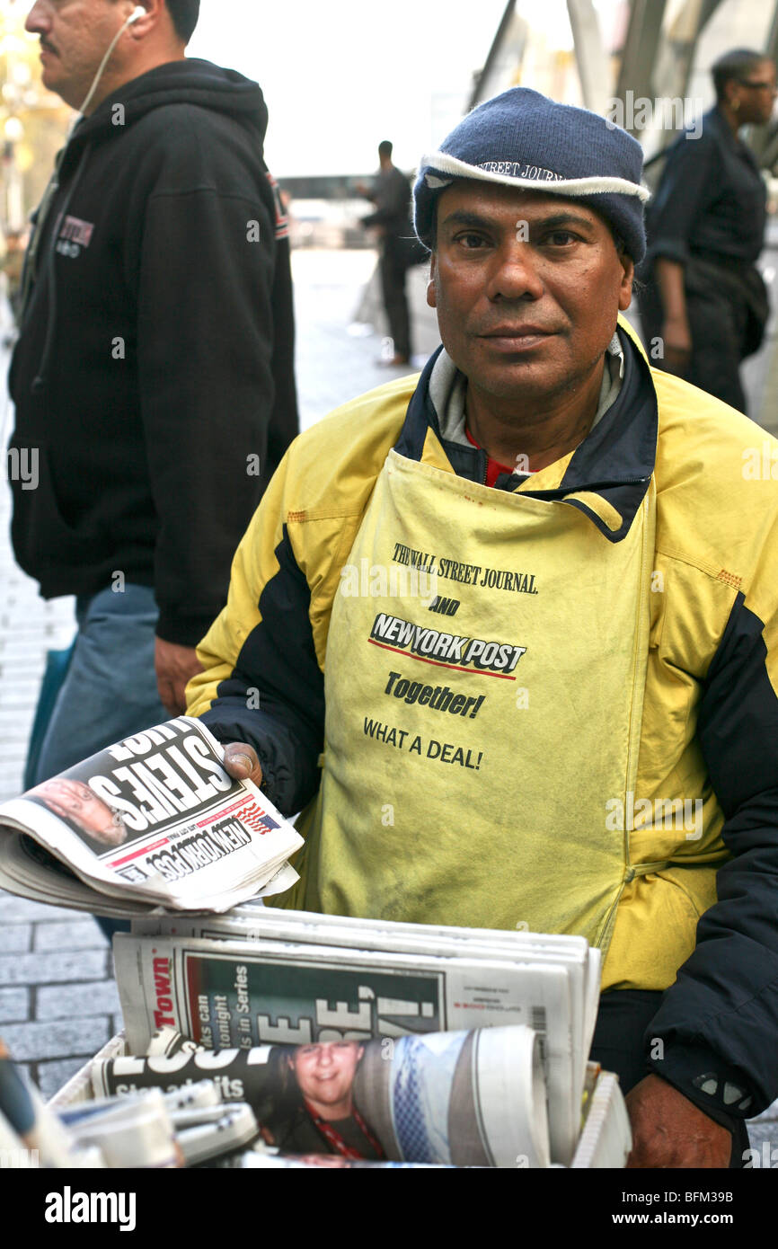 good humored dark skinned man selling the New York Post newspaper on the plaza at Bowling Green in Lower Manhattan New York City Stock Photo