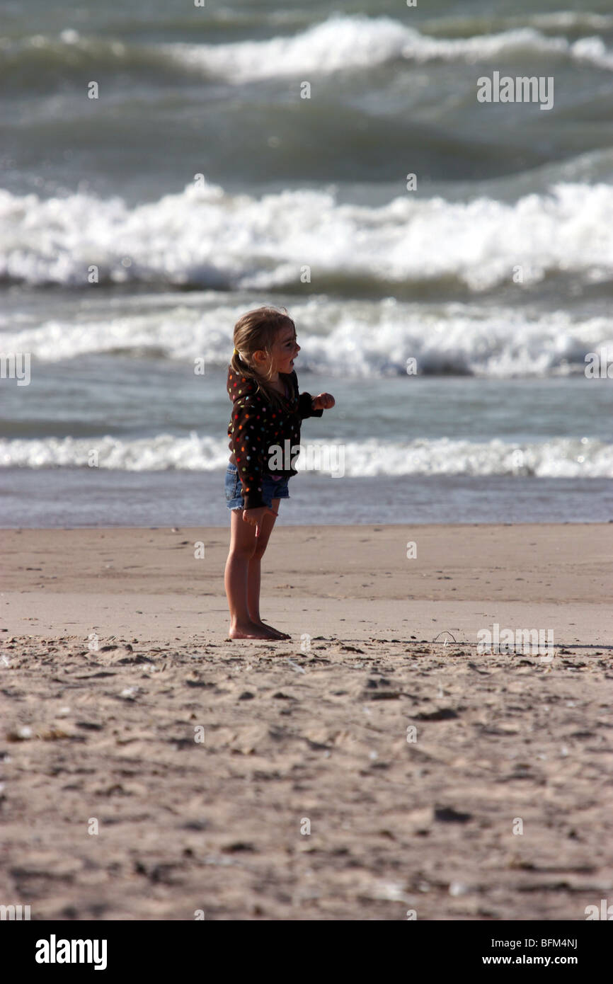 Little girl standing on beach Stock Photo