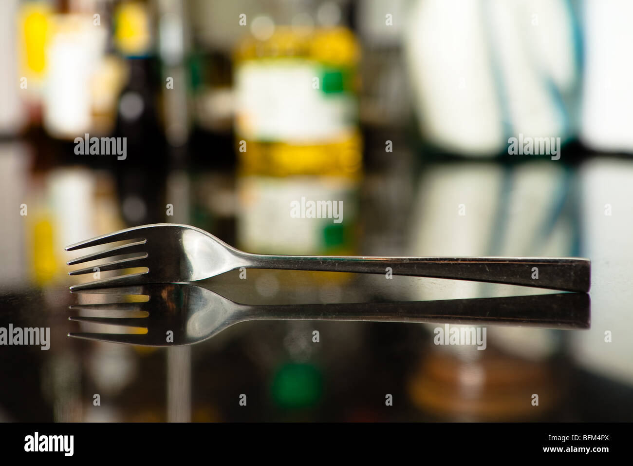 Old and Scratchy Fork with its reflection isolated by shallow depth of field. Stock Photo