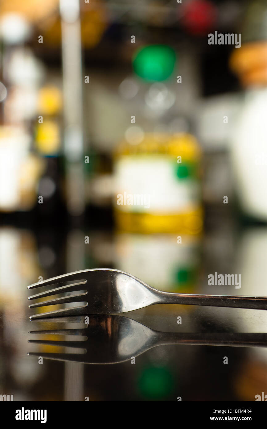 Old and Scratchy Fork with its reflection isolated by shallow depth of field. Stock Photo