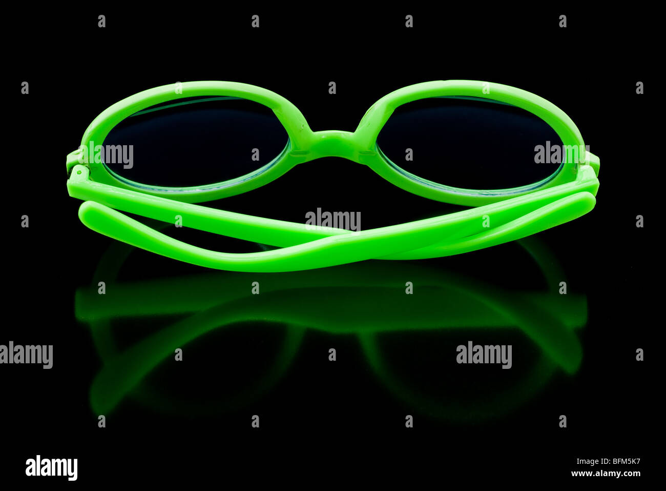 Bright green sunglasses on shiny black background Stock Photo