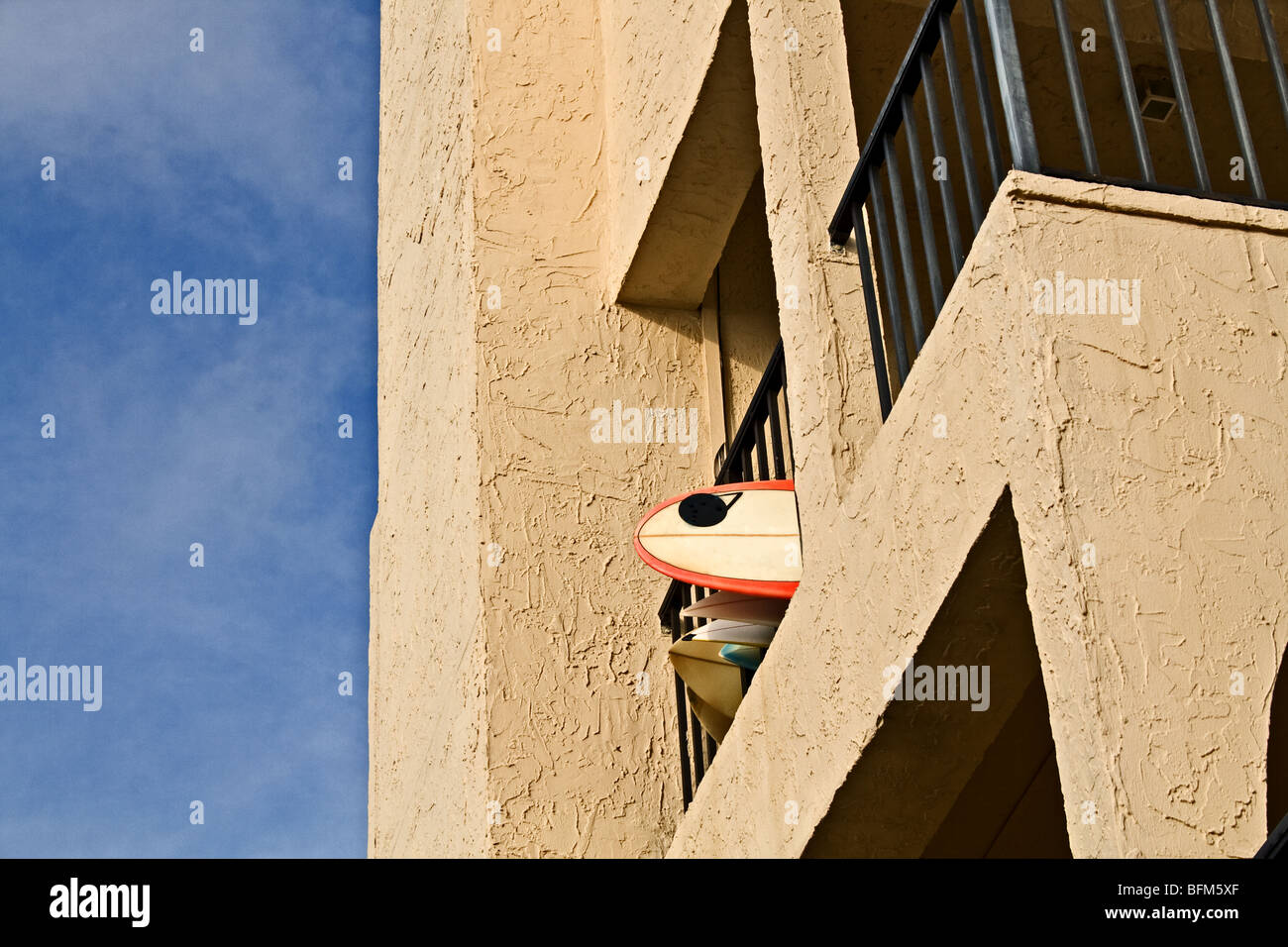 Surfboards hanging out from a metal balcony on a bright sunny day Stock Photo