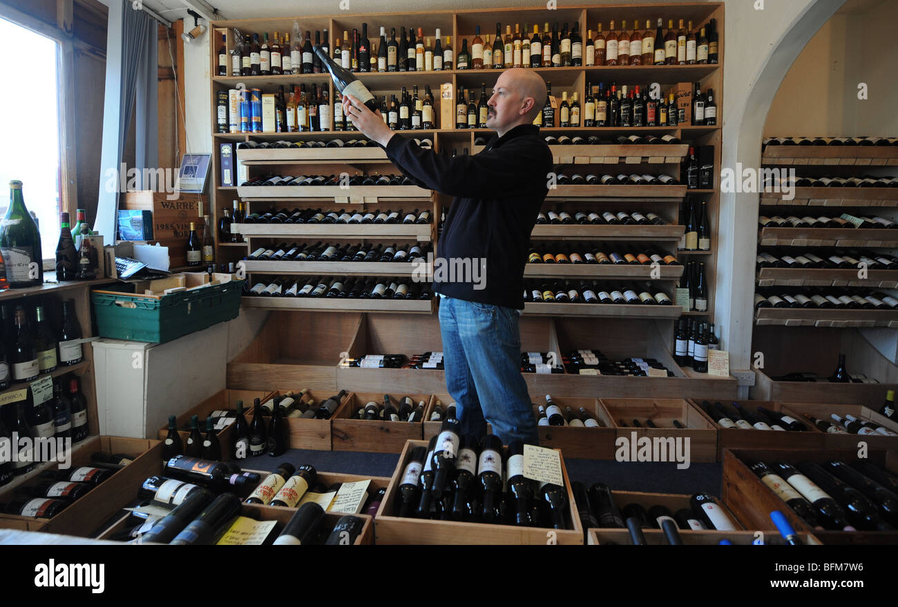 Proprietor Henry Butler admires a bottle of wine at his shop Butlers