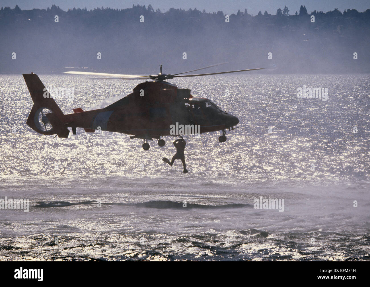 A United States Coast Guard USCG Rescue Swimmer being lifted from the sea Stock Photo