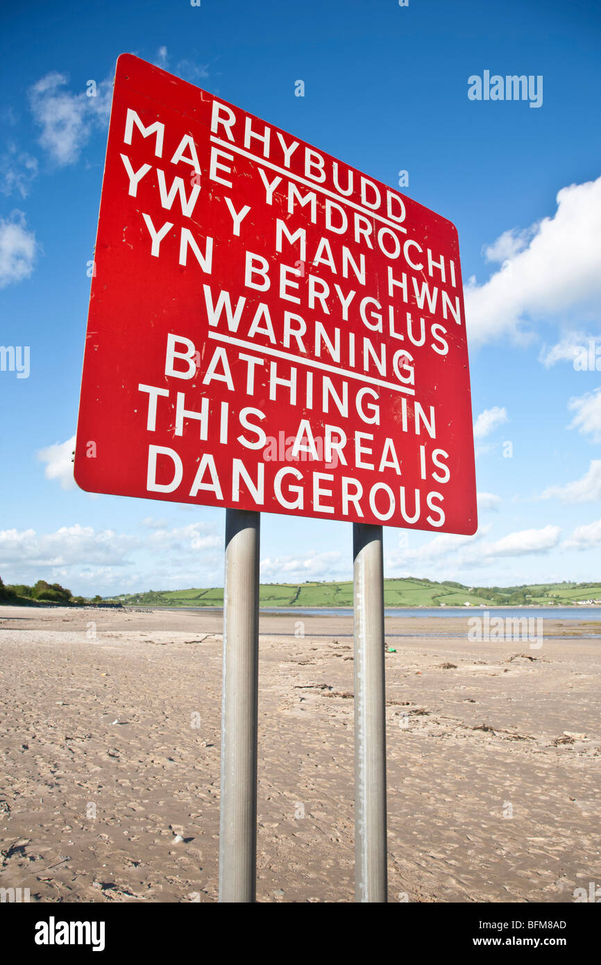 Welsh Language Signs Wales - Bi-lingual Bathing Is Dangerous warning sign on a beach in West Wales. Stock Photo