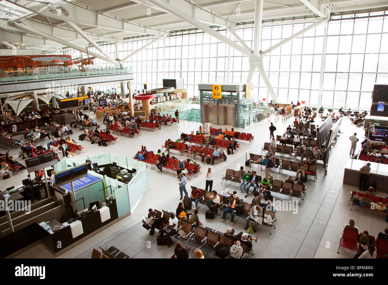 People waiting for flights on concourse of Terminal 5 Heathrow London