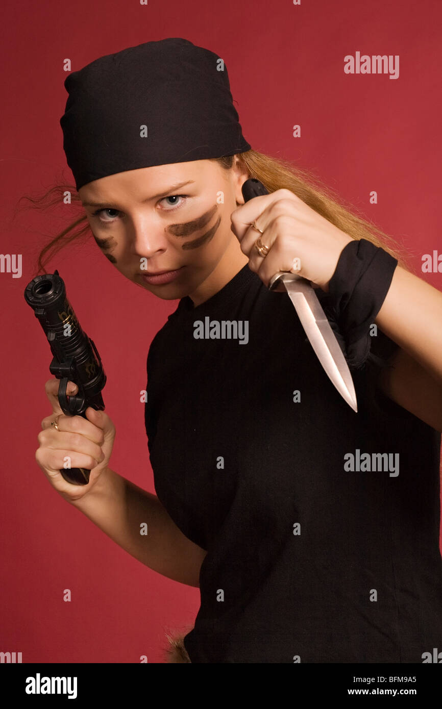 beautiful girl in pirate costume with knife and pistol Stock Photo