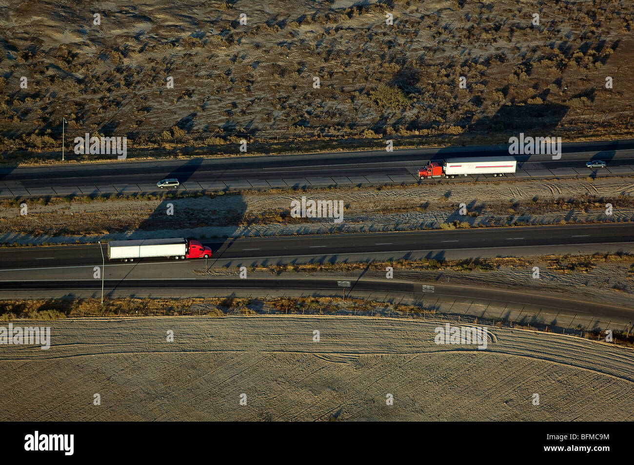 aerial view above approaching trucks interstate 5 California central valley Stock Photo