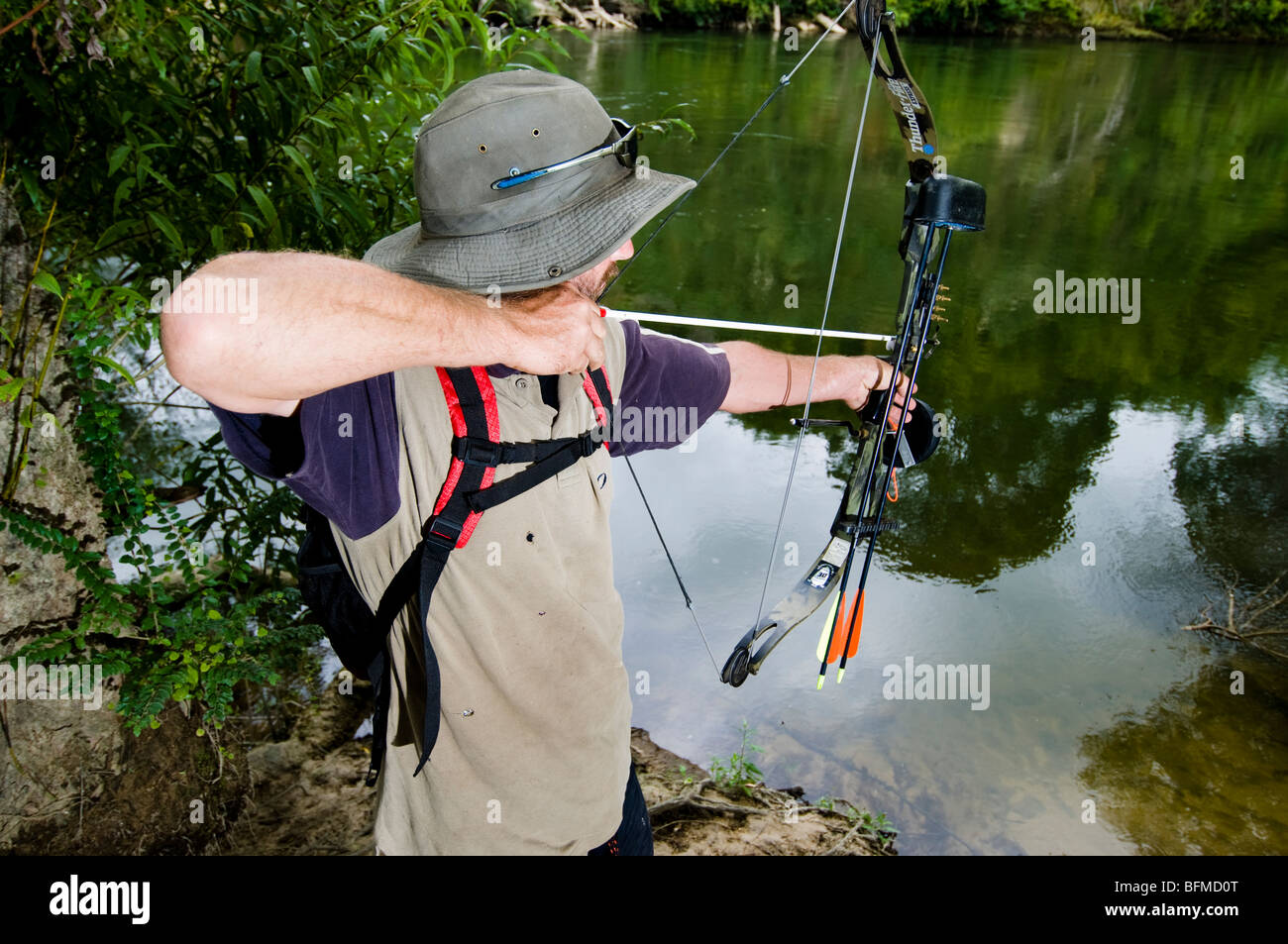 Boy fishing in a lake with a bow and arrow, Lago Miwa, as