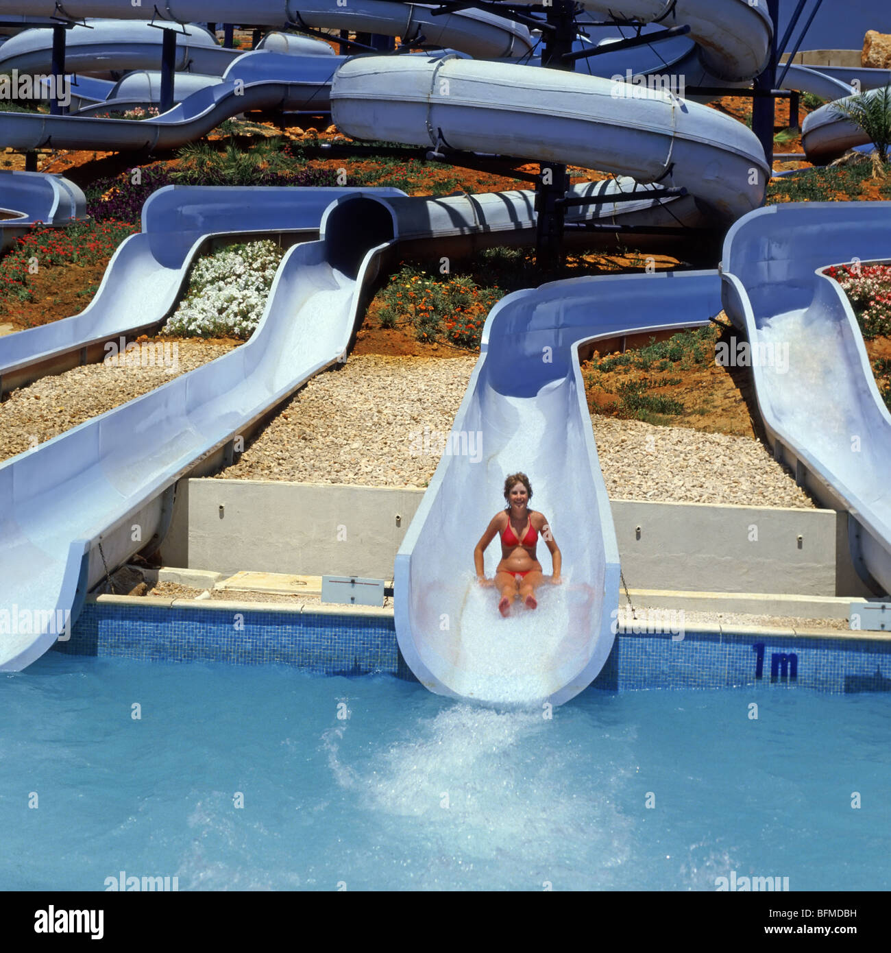 Water park with girl sliding off water chute at speed one person