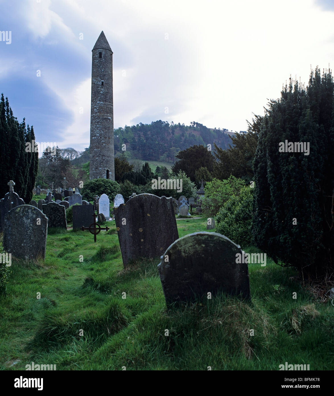 Restored round tower in graveyard of the monastic ruins at Glendalough in County Wicklow in Ireland Stock Photo