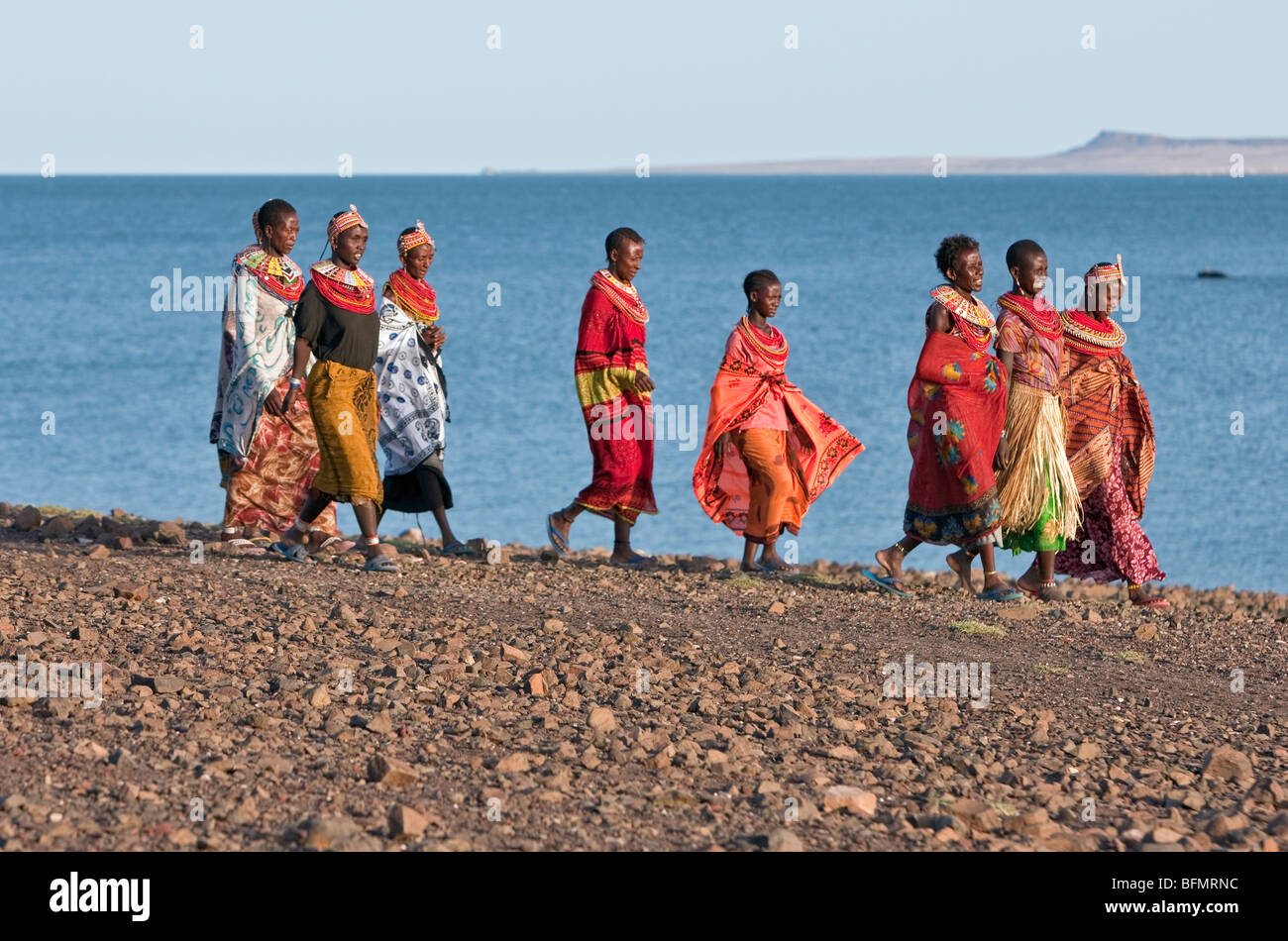 A group of El Molo women walk along the barren shoreline of Lake Turkana  s El Molo Bay. Stock Photo